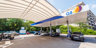 Een Q8 tankstation met verschillende auto's op de forcourt.