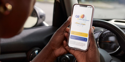 Femme tient son smartphone avec l'appli Q8