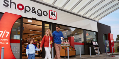 Famillie stapt shop & go winkel buiten bij Q8 station