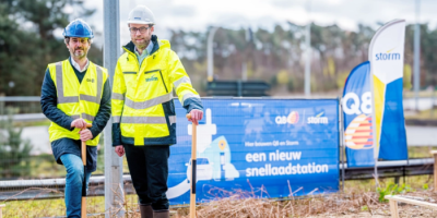 2 mannen in een fluo vest en een helm op die een laadpaal hebben geplaatst.