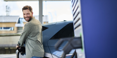Man laad zijn auto aan Q8 electric lader