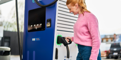 Une femme se rebranche sur la borne de recharge Q8 electric