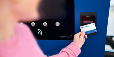 Une femme scanne la carte Q8 electric à la station de recharge