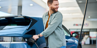 Un homme débranche sa voiture électrique à une station de recharge Q8 electric.